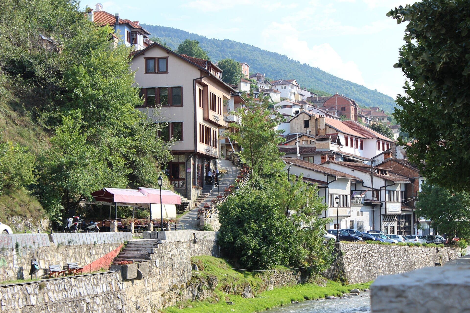 Old town houses climbing the hillside above the river in Prizren